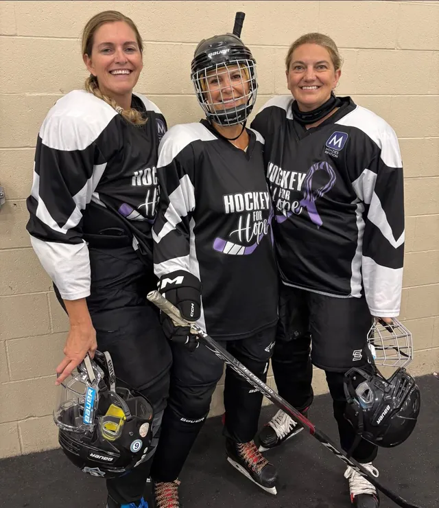 Three players in Hockey for Hope jerseys standing together off the ice